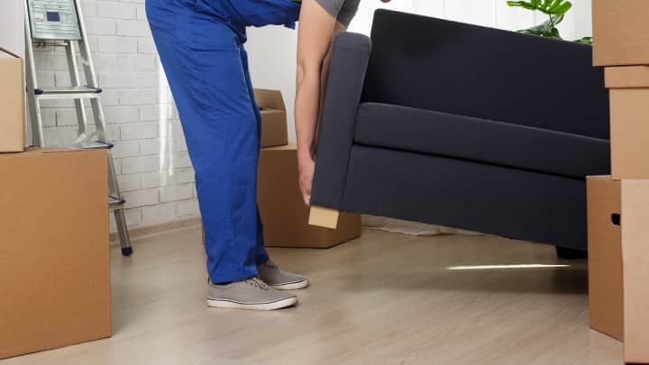 Man lifting a sofa on one side