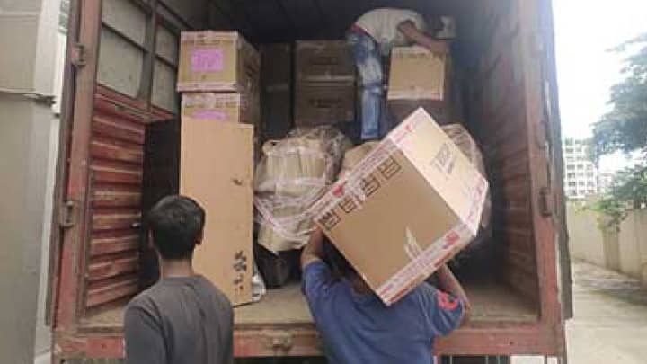Movers loading heavy items into truck