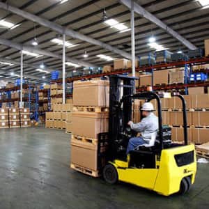 Storage and Warehousing Man Using Forklift to Move Boxes in Warehouse