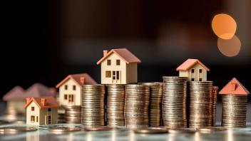 Photo of Miniature Houses on Stack of Coins
